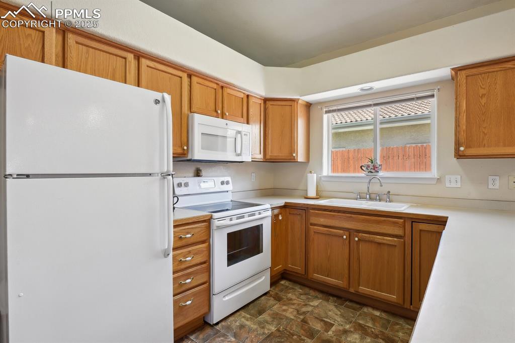 Image 11 of 29: Kitchen featuring white appliances and sink