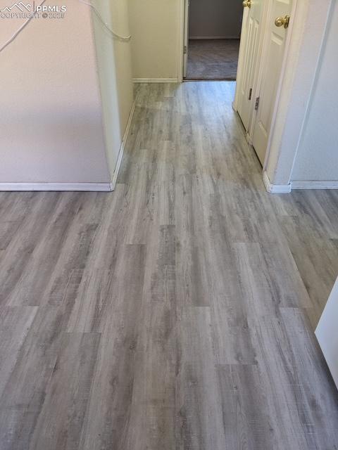 Image 14 of 29: Hallway featuring wood finished floors and baseboards
