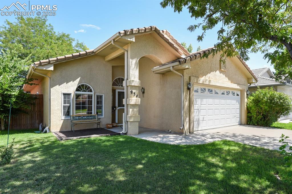 Image 3 of 29: View of front of property featuring a garage and a front lawn
