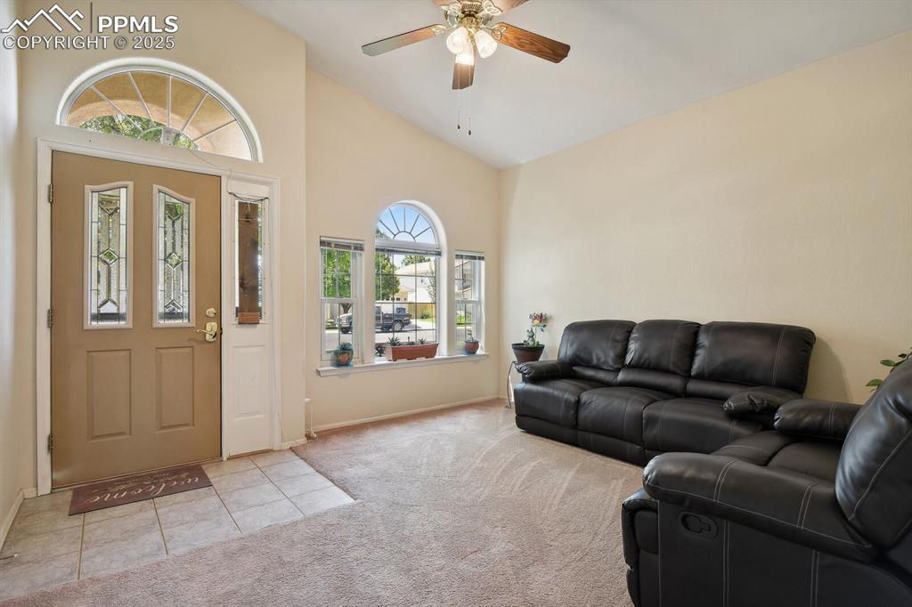 Image 8 of 29: Carpeted foyer entrance featuring ceiling fan and high vaulted ceiling