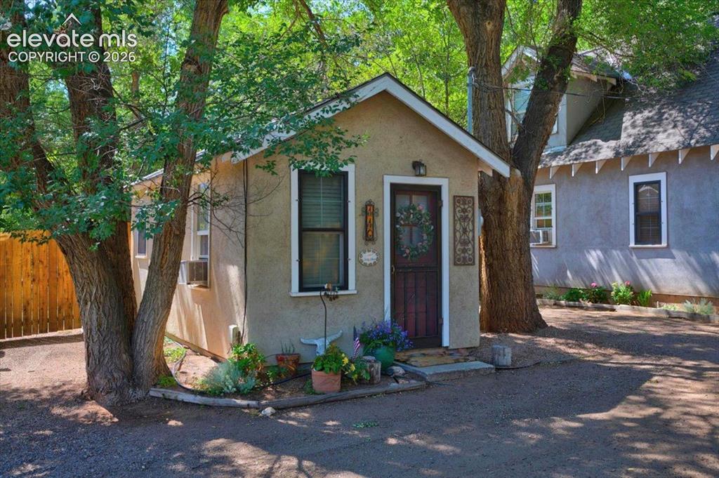 Image 28 of 50: Sweet Rose Cottage Exterior – Charming standalone cottage nestled among mat