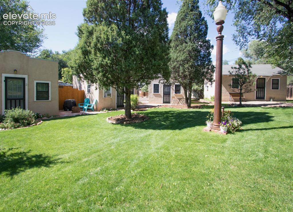 Image 33 of 50: Shared Courtyard – Beautifully maintained common courtyard with mature tree