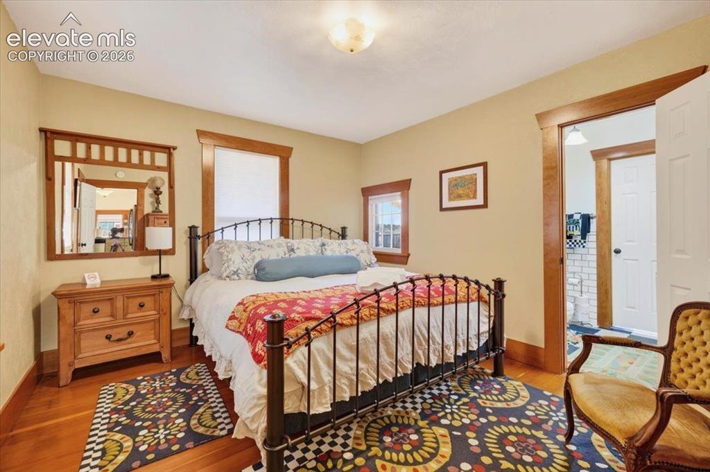 Image 8 of 50: Primary Bedroom – Comfortable main-level bedroom featuring hardwood floors,