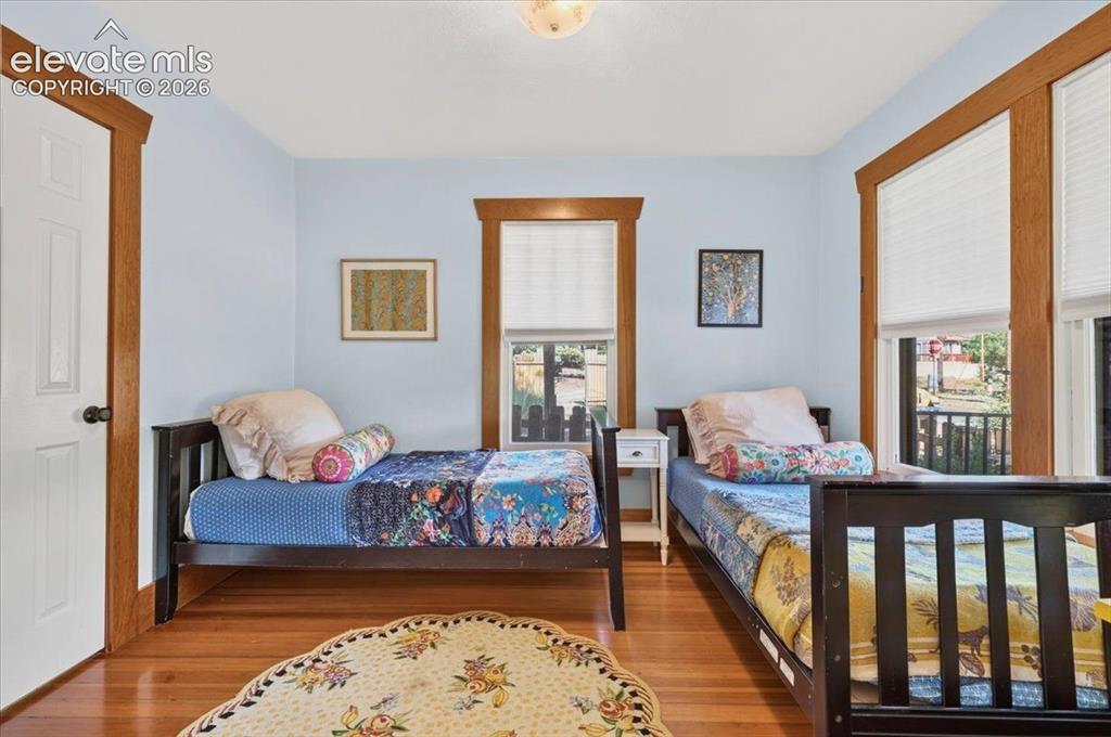 Image 9 of 50: Guest Bedroom – Bright secondary bedroom with hardwood flooring, large wind