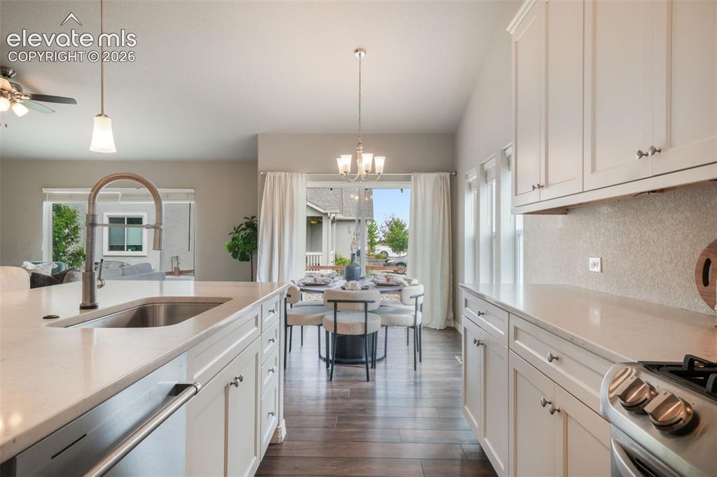 Image 11 of 49: Contemporary kitchen featuring white cabinetry, light countertops, a stainl