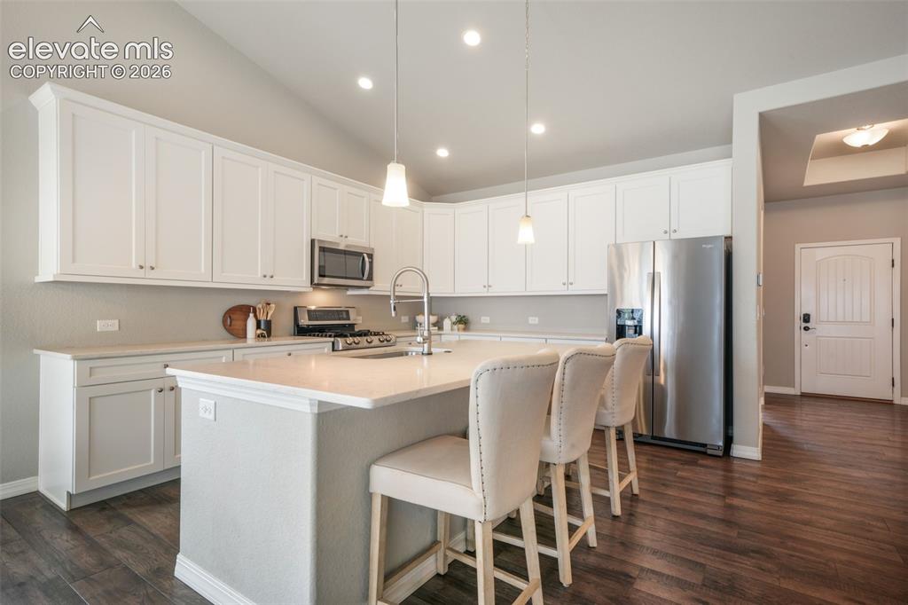 Image 5 of 49: Kitchen featuring white cabinetry, a central island with countertop seating
