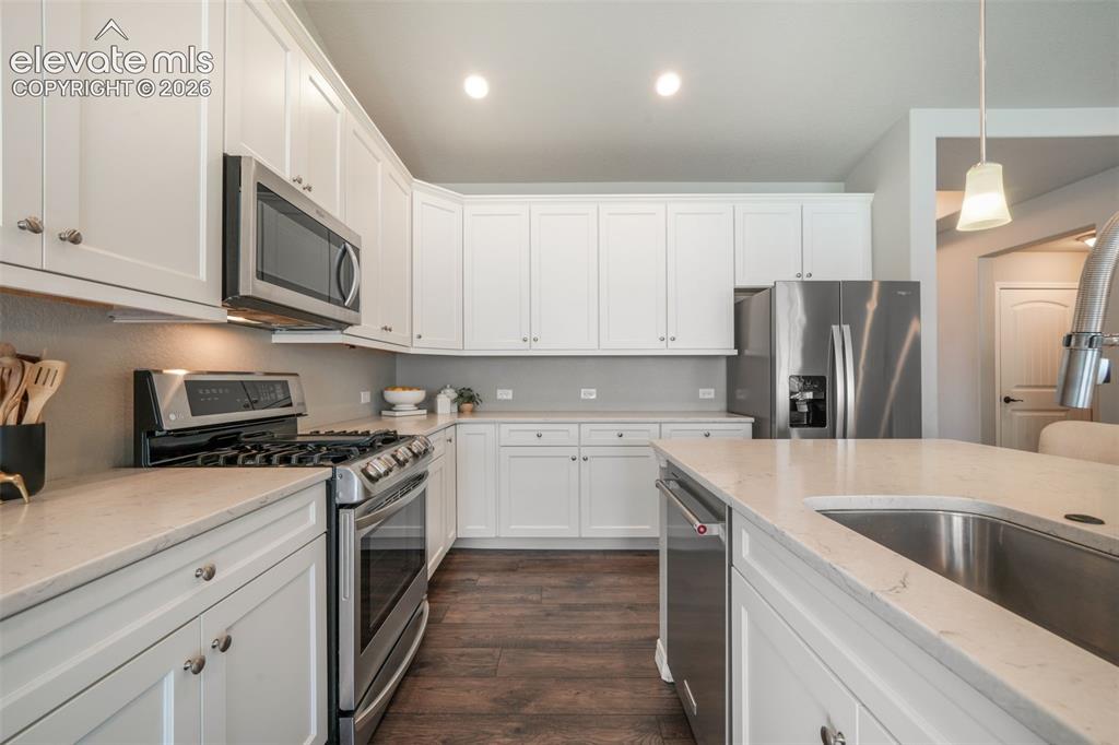 Image 6 of 49: kitchen featuring white cabinetry, light-toned countertops, and LVP
