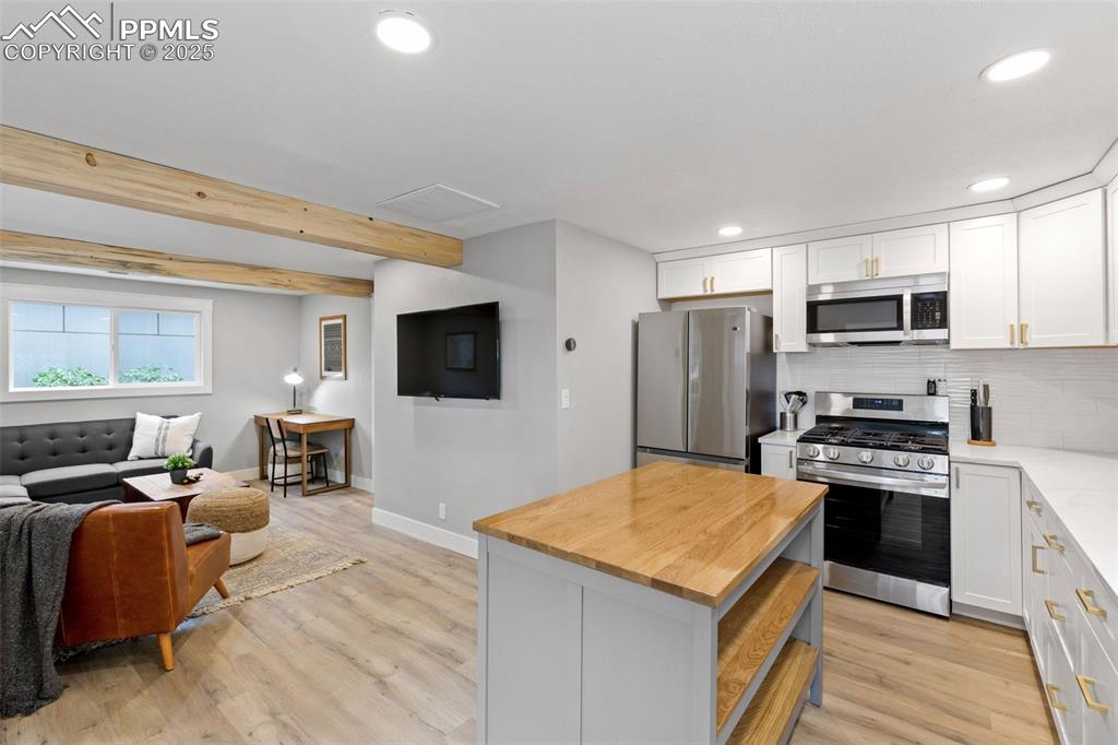 Image 9 of 15: Kitchen featuring decorative backsplash, appliances with stainless steel fi