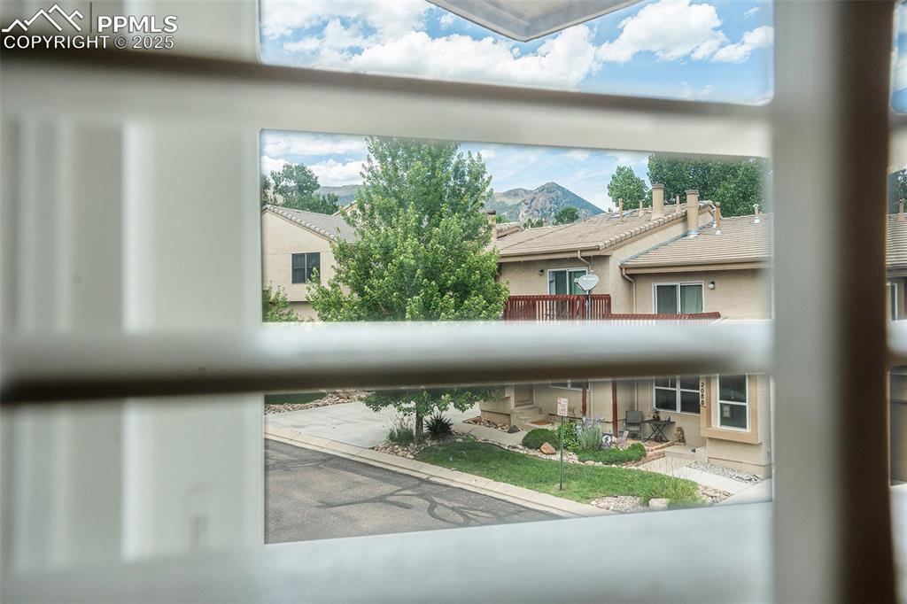 Image 11 of 23: Mountain view from primary bedroom with plantation shutters 