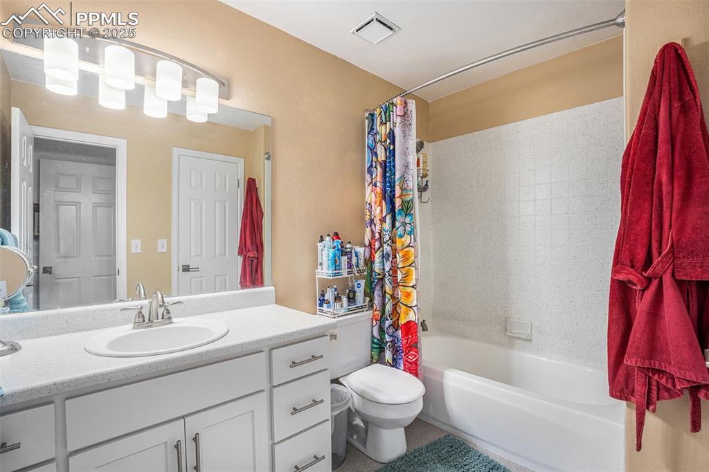 Image 13 of 23: Full bathroom featuring shower / tub combo and vanity. Flooring, countertop