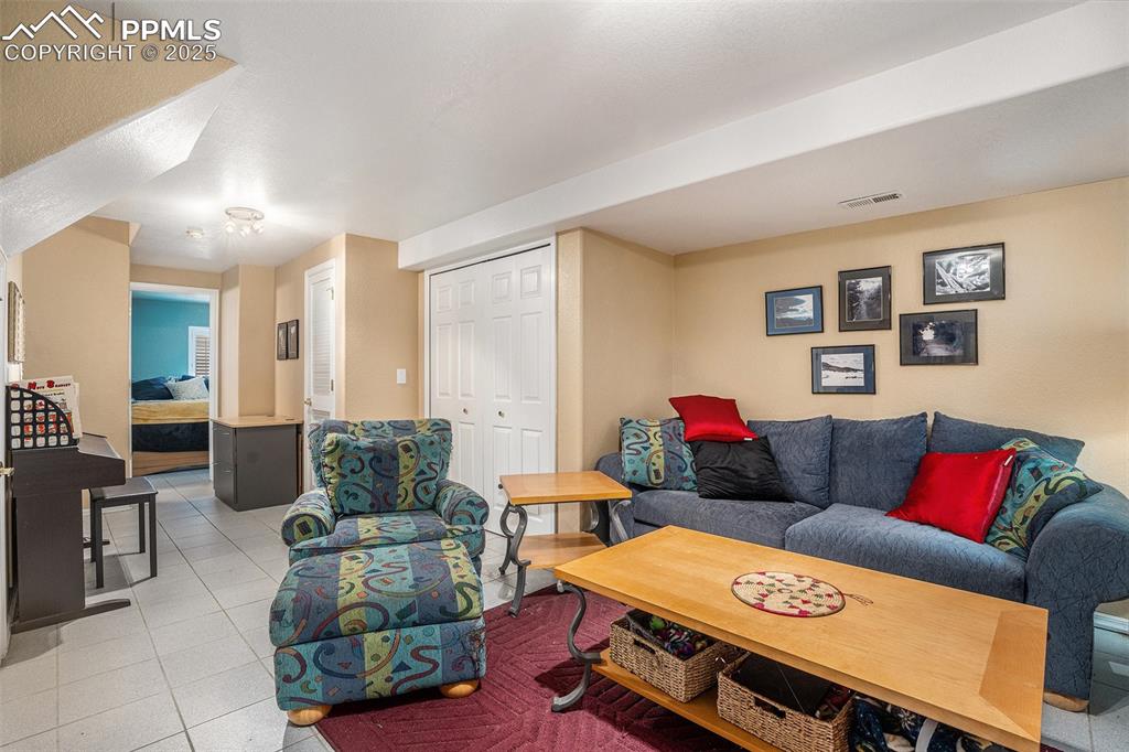 Image 16 of 23: Living area featuring light tile patterned flooring