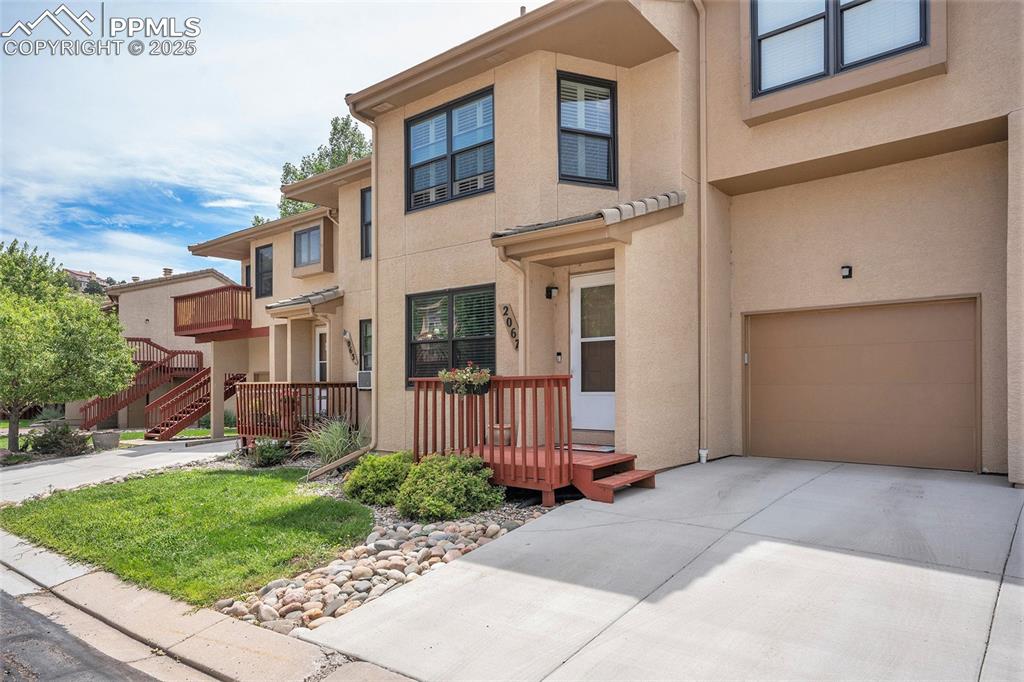 Image 2 of 23: View of front of home with a garage, newer concrete driveway, stucco siding