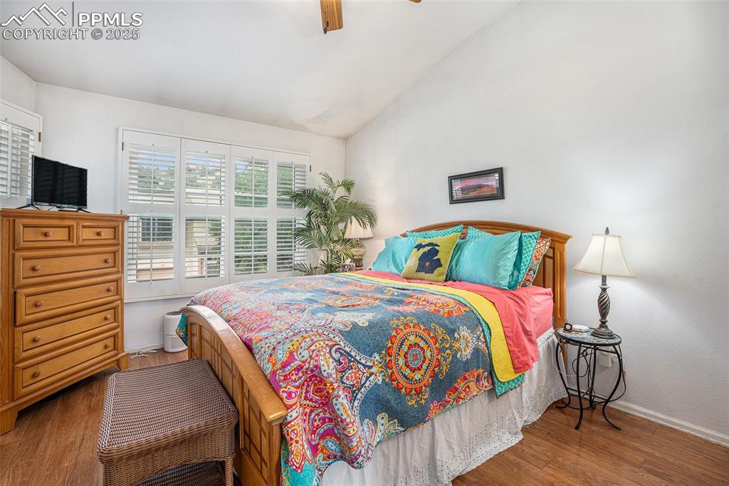 Image 9 of 23: Upper primary bedroom with newer floors, vaulted ceiling, plantation shutte