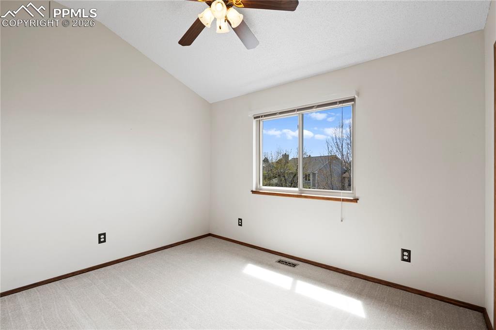 Image 24 of 46: This room features an angled ceiling, a ceiling fan, and carpeted flooring