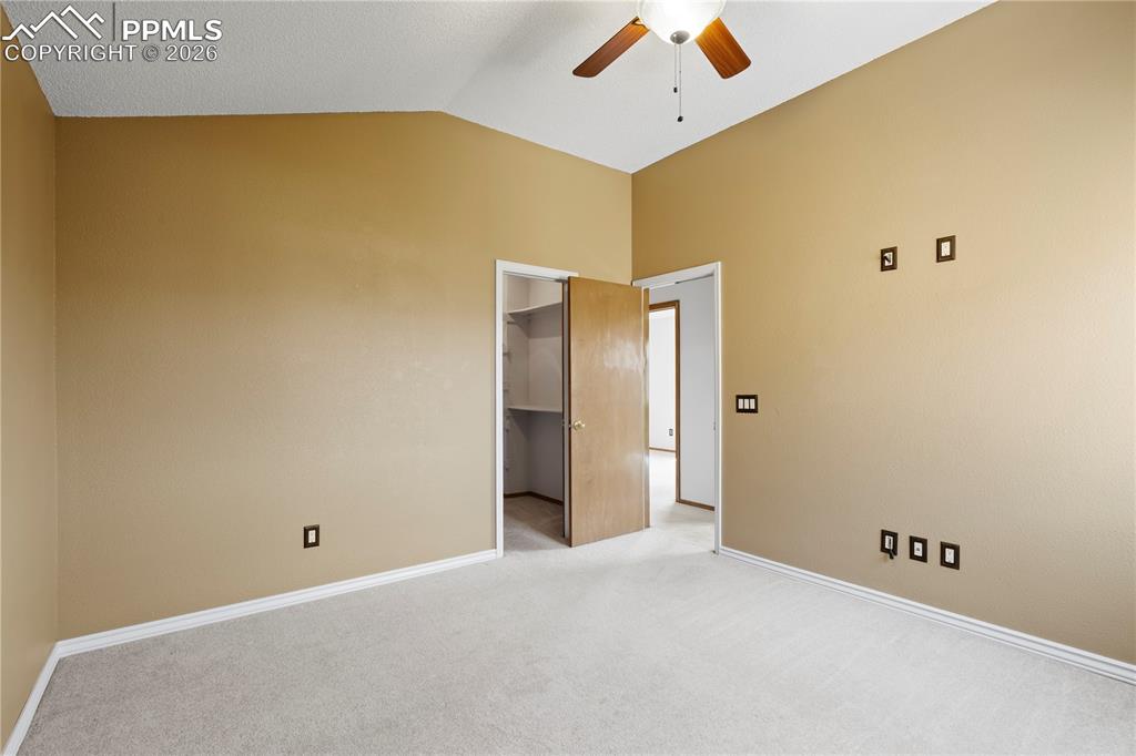 Image 29 of 46: Room with carpet flooring, vaulted ceiling, and a ceiling fan with light fi