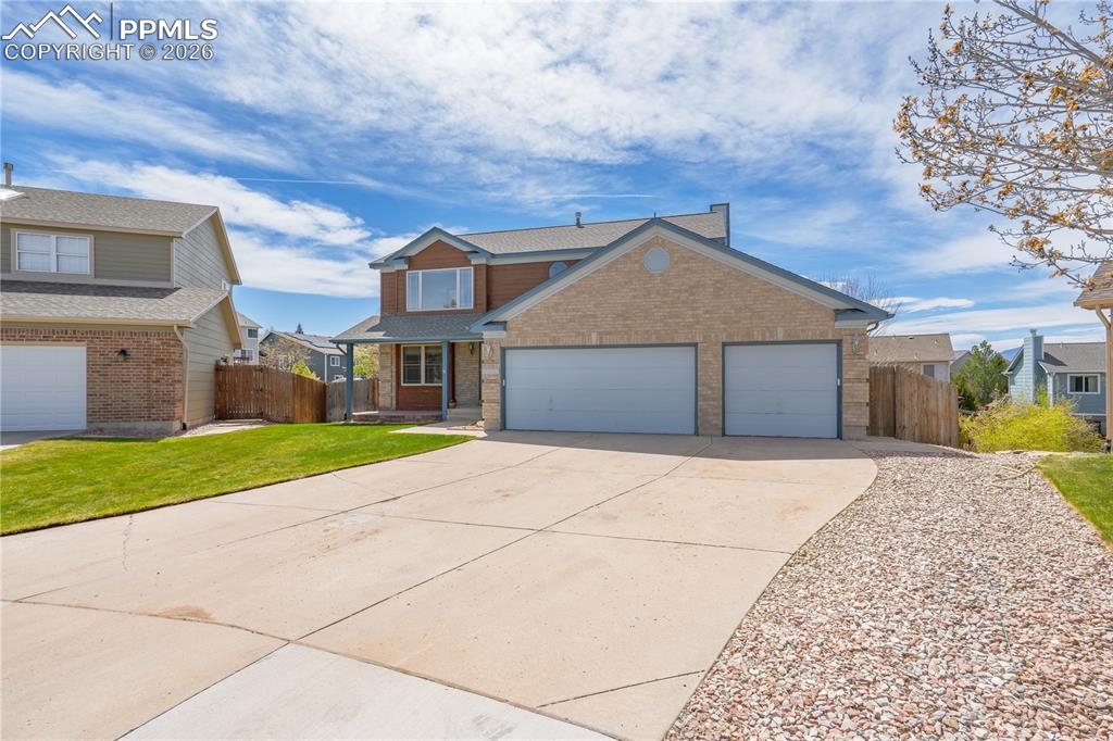 Image 3 of 46: The property features a brick and siding exterior, a two-car garage, a conc
