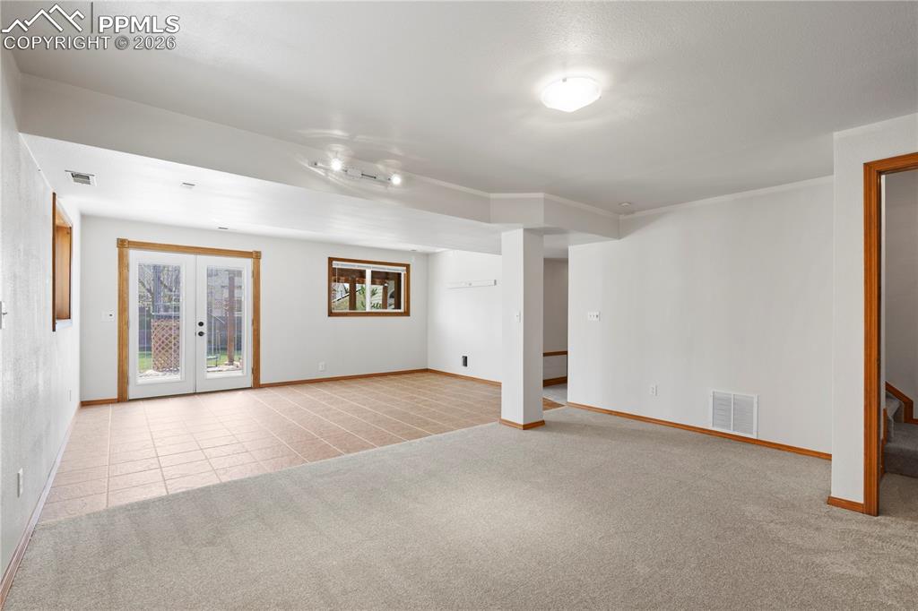 Image 30 of 46: Walk-out Basement room featuring light-colored carpet and tiled flooring, w