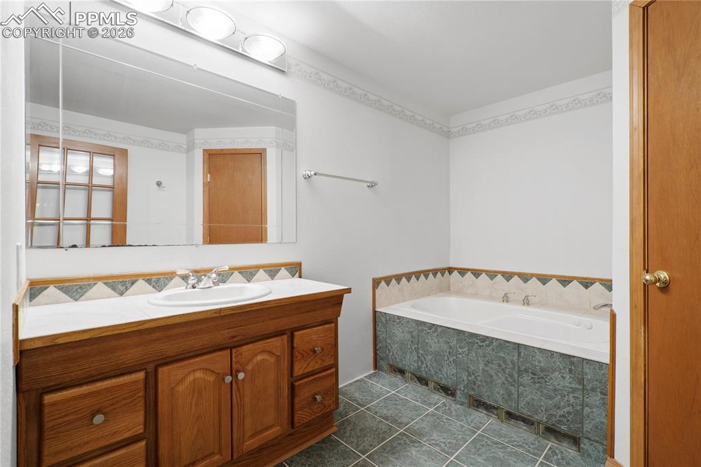 Image 34 of 46: Bathroom featuring a wooden vanity with a white countertop and an integrate