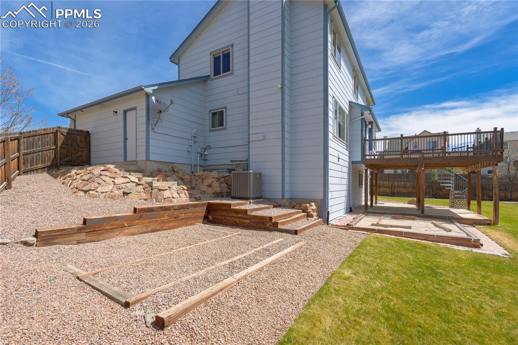 Image 35 of 46: The property features a fenced yard with both a gravel area and a lawn