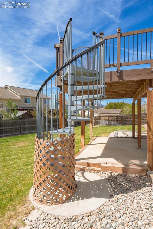 Image 40 of 46: The property features a spiral staircase with metal railings leading to a w