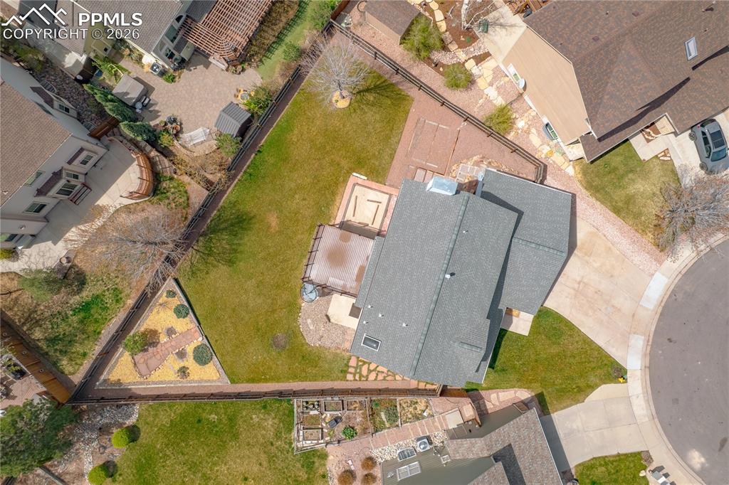 Image 46 of 46: The property features a spacious rear yard with a lawn, a patio area, and m