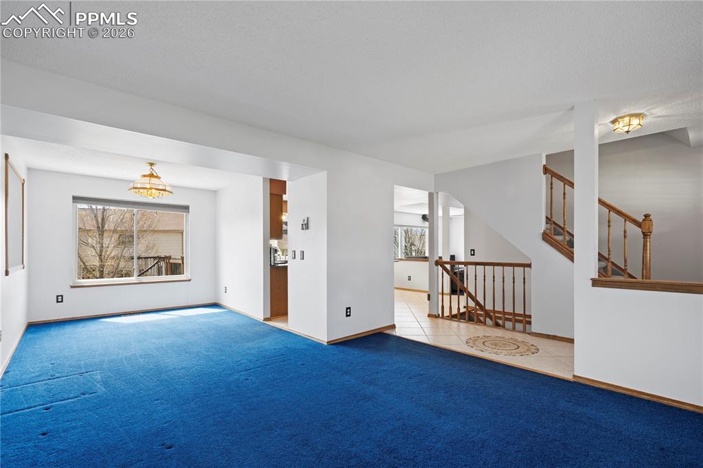 Image 5 of 46: The property features white walls, carpeting, and a window providing natura