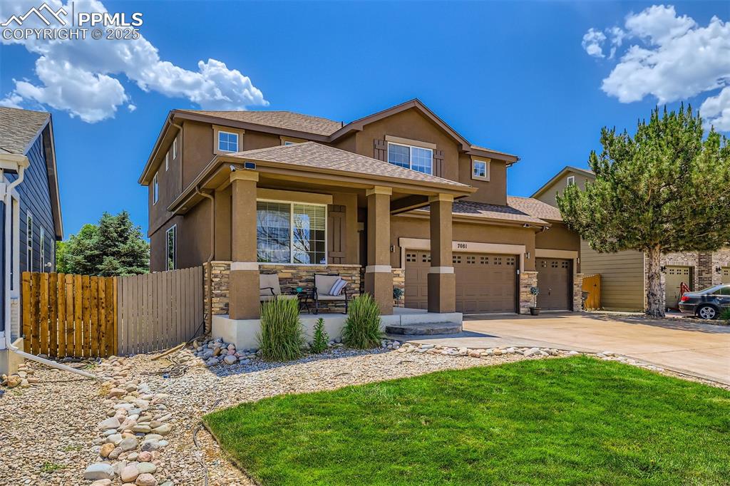 Caption: View of front of home featuring stucco siding, stone siding, and driveway