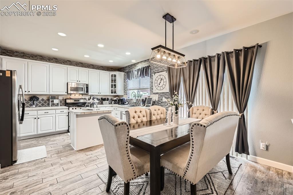 Image 10 of 30: Dining room with light wood-type flooring, recessed lighting, and a chandel