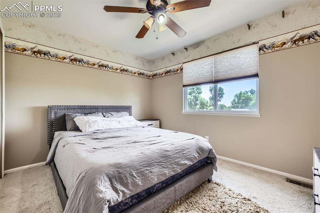 Image 12 of 30: Carpeted bedroom with baseboards and a ceiling fan