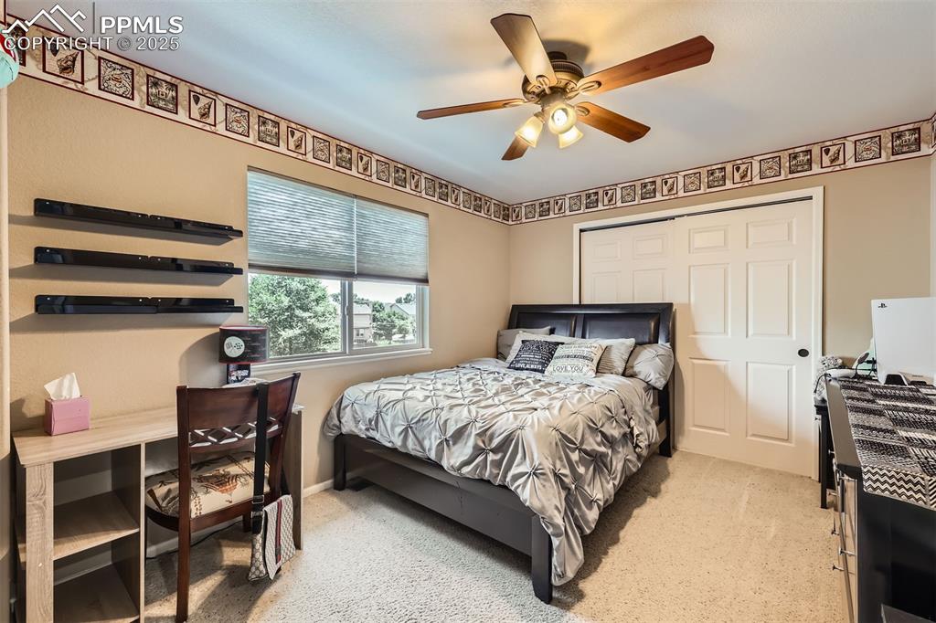 Image 14 of 30: Bedroom with light colored carpet and ceiling fan