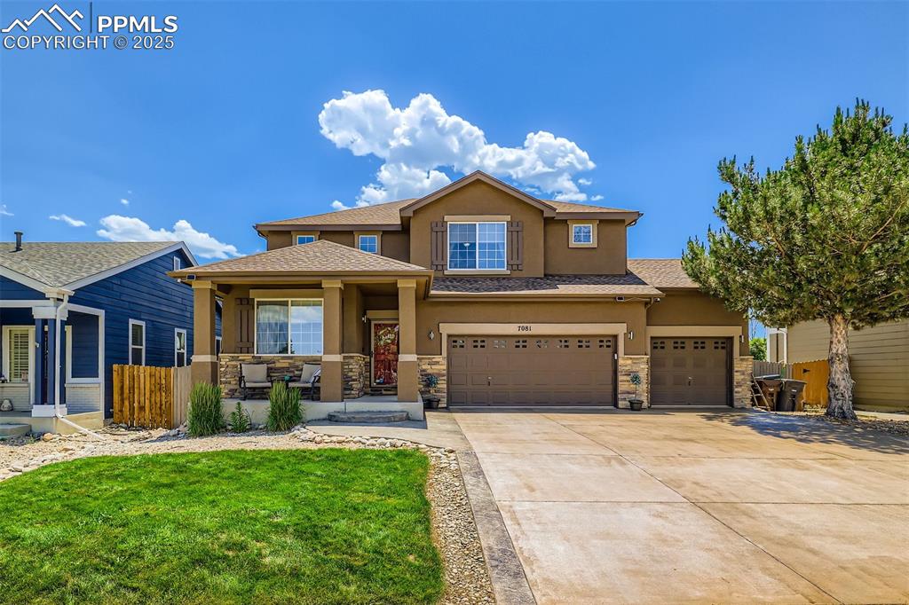 Image 3 of 30: View of front of house with stucco siding, stone siding, concrete driveway,