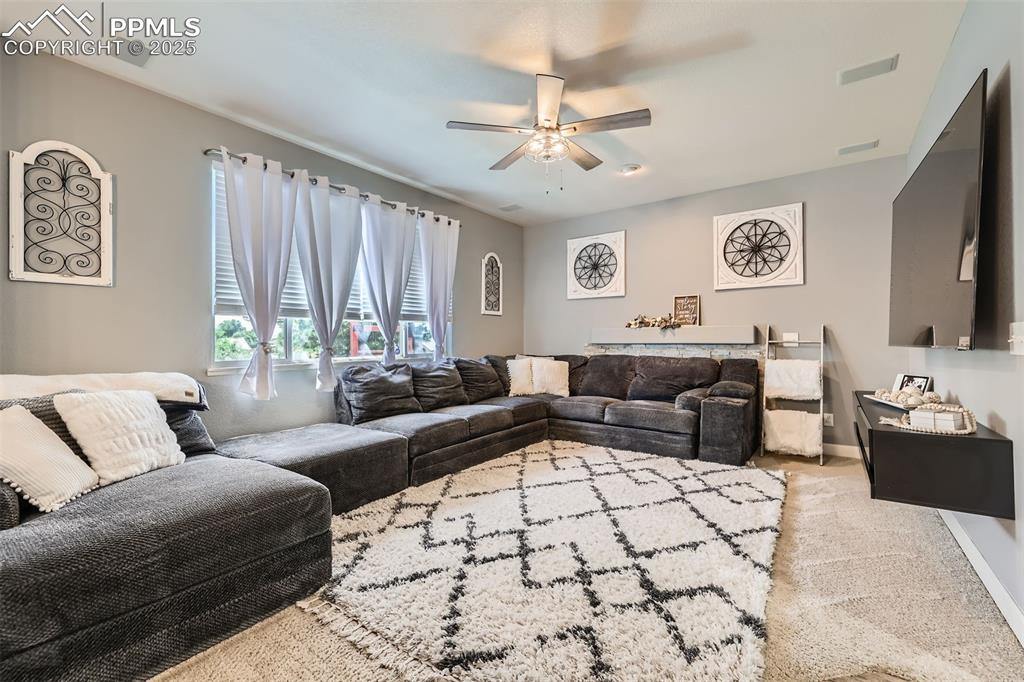 Image 6 of 30: Carpeted family room area with ceiling fan and baseboards