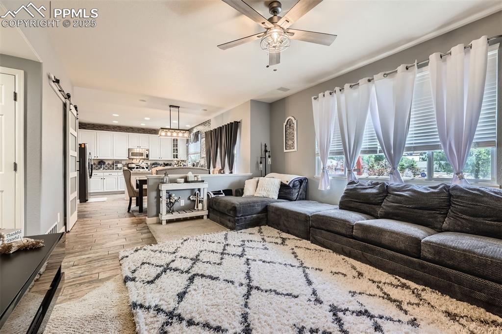 Image 7 of 30: Family room area with light wood finished floors, ceiling fan, plenty of na
