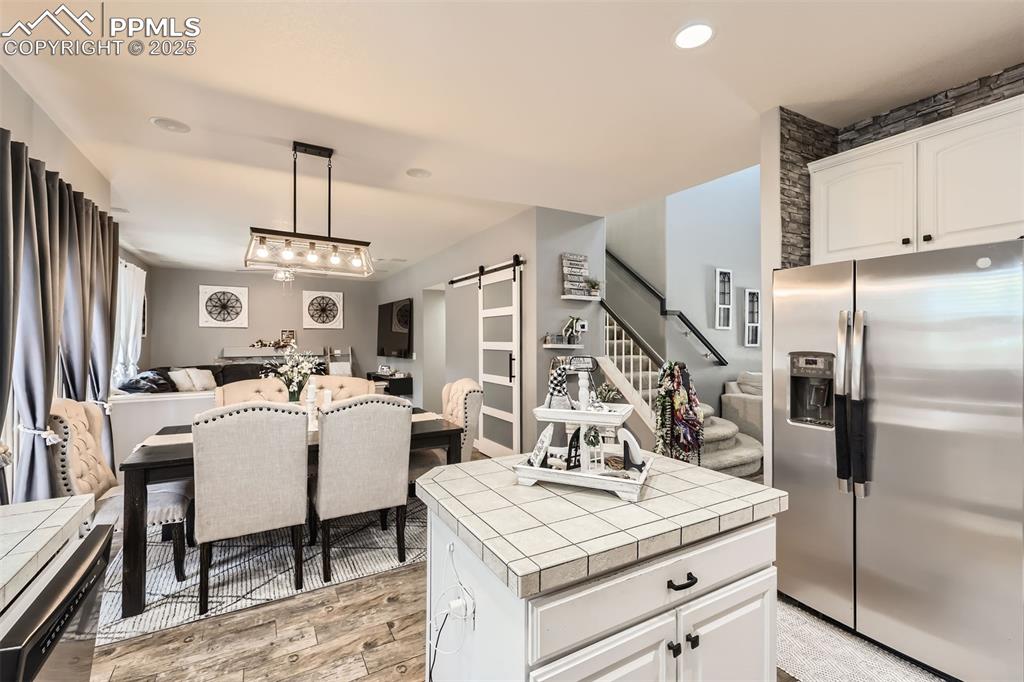 Image 9 of 30: Kitchen featuring stainless steel refrigerator with ice dispenser, tile cou