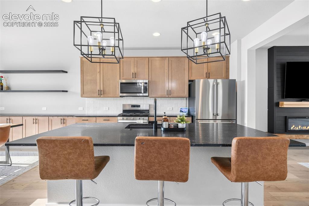 Image 15 of 48: The maple-toned cabinetry carries from the kitchen into the dining area for