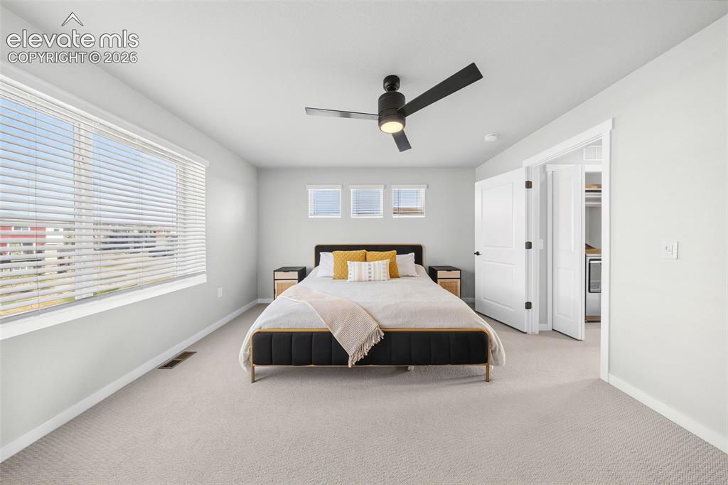 Image 27 of 48: The primary bedroom is at the back of the upper level. It has space for a k