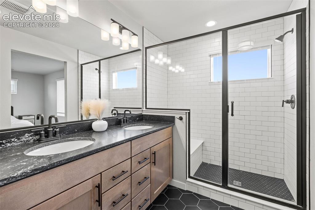 Image 32 of 48: Gorgeous tilework and a built-in seat make the double-sized shower an absol