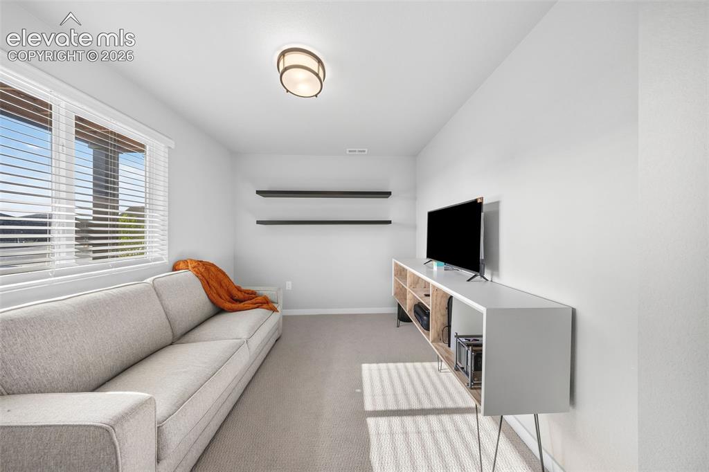 Image 34 of 48: This lower-level bedroom is currently in use as an office. It has an adjace
