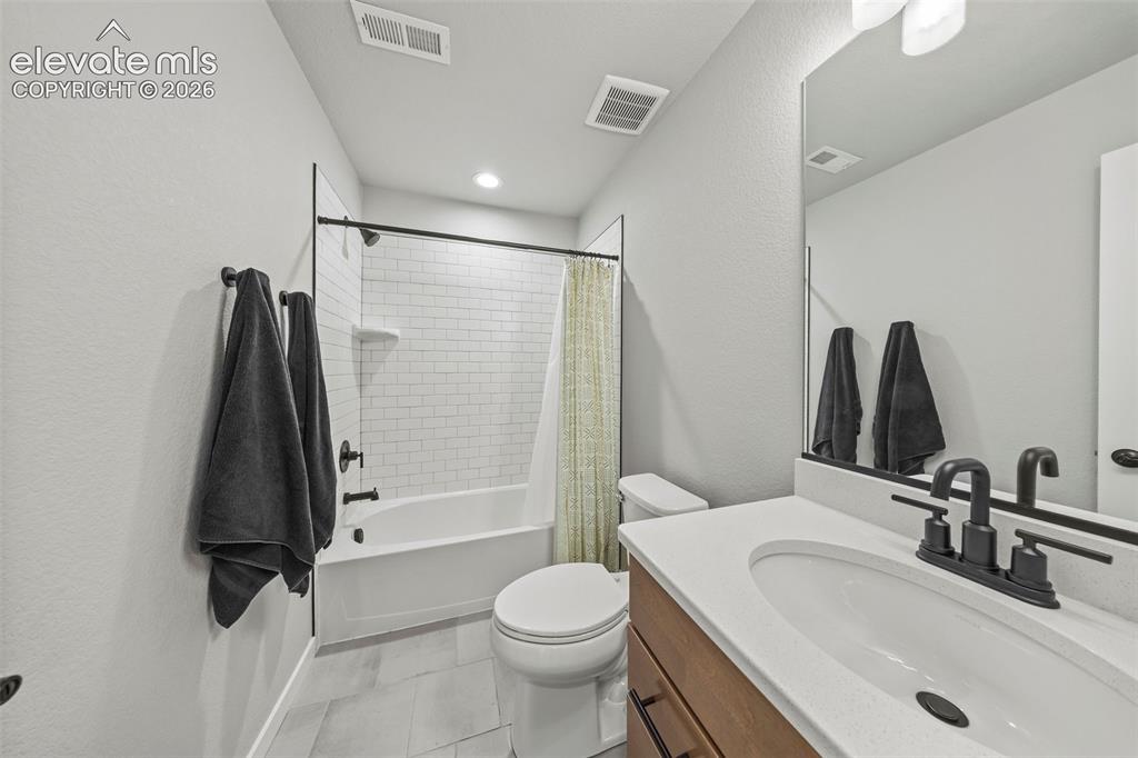 Image 35 of 48: The lower-level bathroom is adjacent to the third bedroom and features a tu