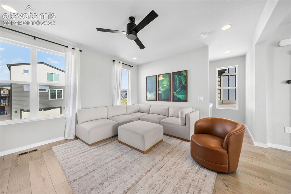 Image 7 of 48: The living room is bright and spacious. With engineered wood floors, large 
