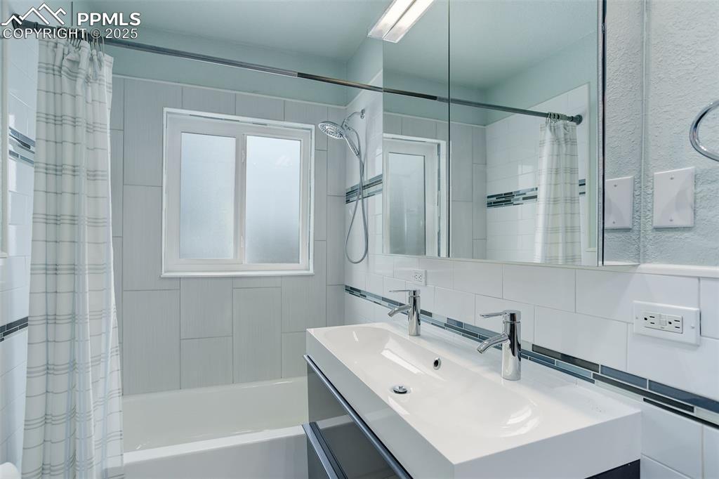 Image 23 of 37: Updated bathroom with ample storage and built-in shelving