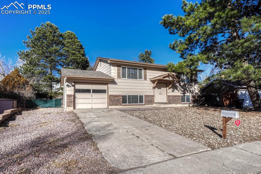 Caption: Split foyer home featuring brick siding, a garage, and concrete driveway