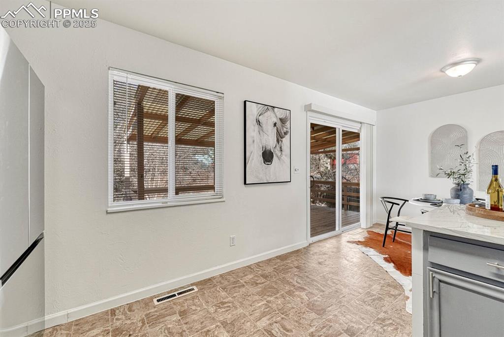 Image 15 of 43: Dining room with baseboards and stone finish flooring
