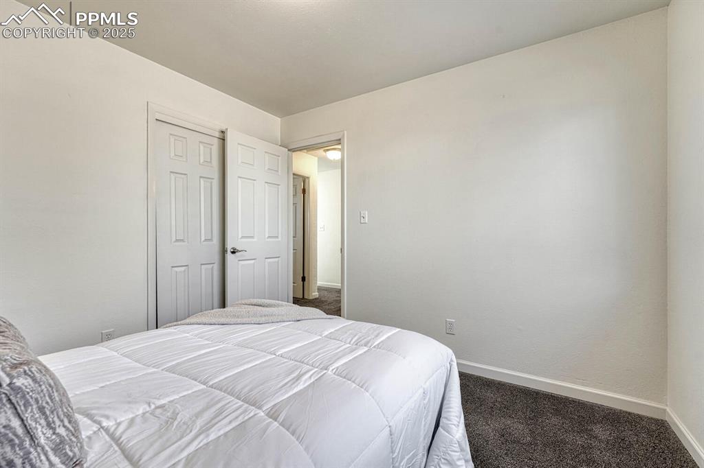Image 20 of 43: Bedroom featuring dark colored carpet and baseboards
