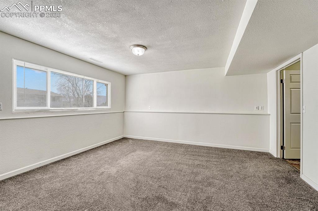 Image 31 of 43: Spare room with a textured ceiling and carpet