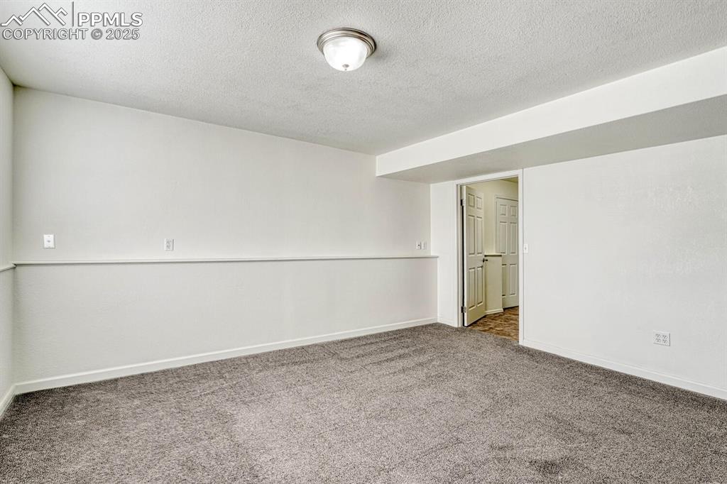 Image 34 of 43: Carpeted empty room featuring baseboards and a textured ceiling