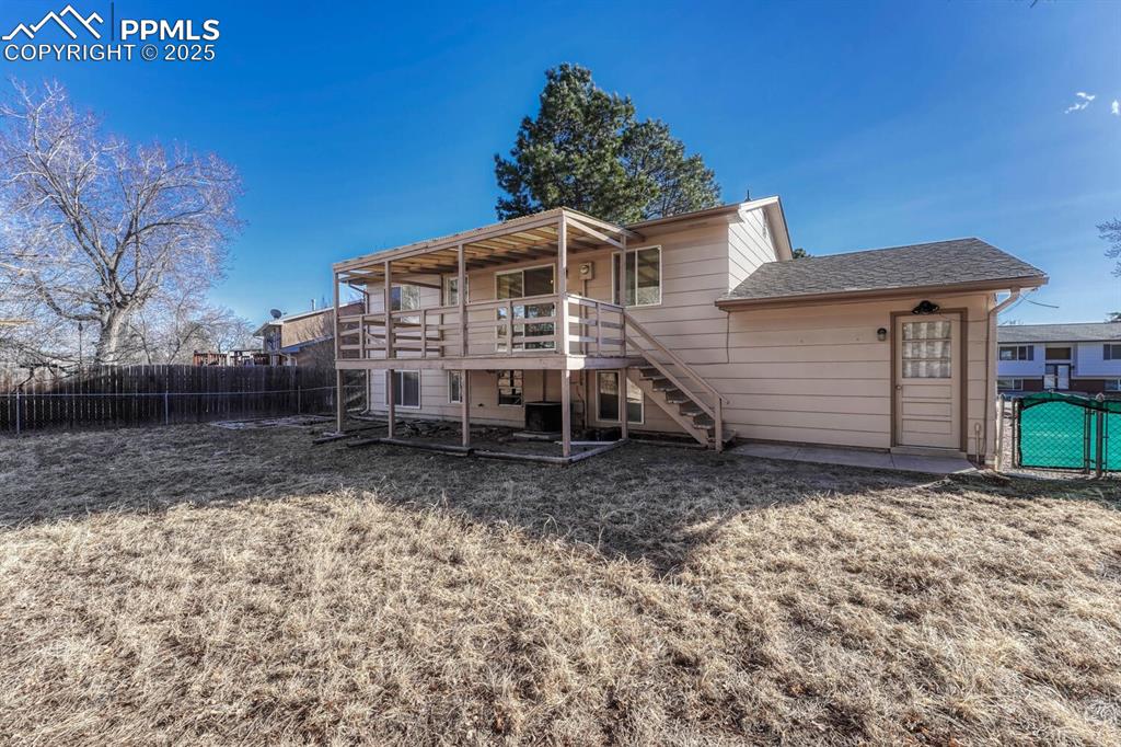 Image 41 of 43: Back of property featuring a fenced backyard, stairway, roof with shingles,
