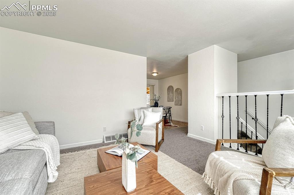 Image 5 of 43: Living area with carpet flooring and arched walkways