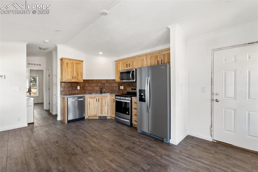 Image 2 of 15: Kitchen, living room and side door.