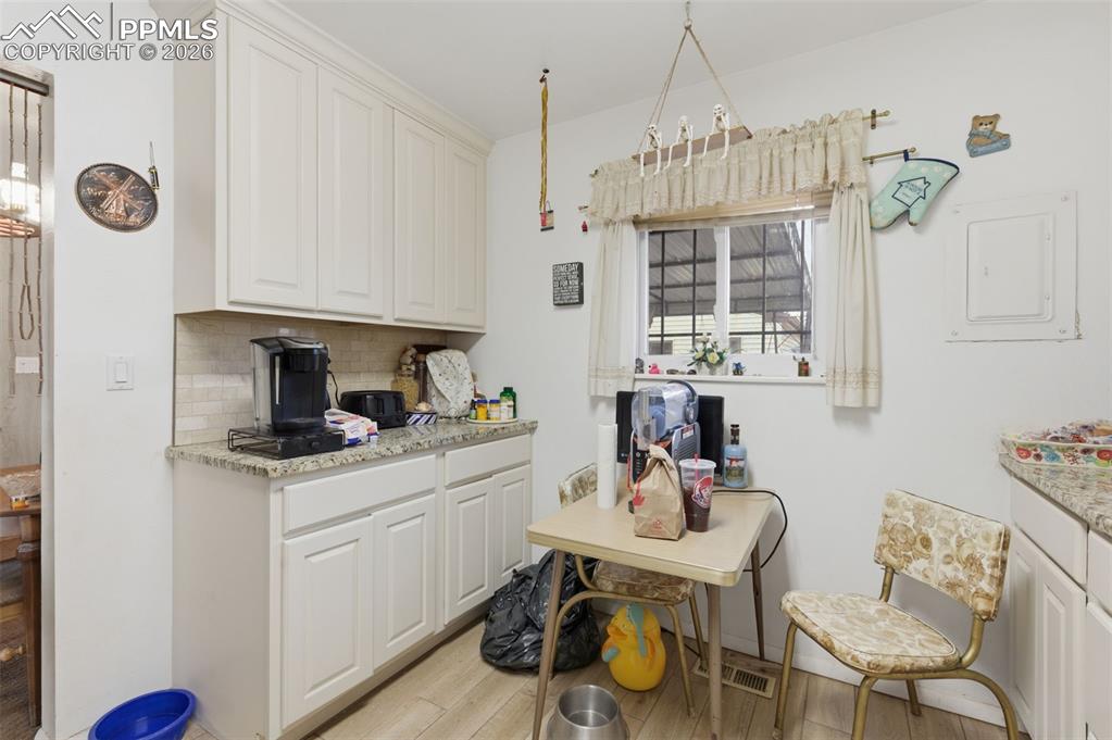 Image 11 of 24: Kitchen featuring white cabinetry, light-toned granite-style countertops, a